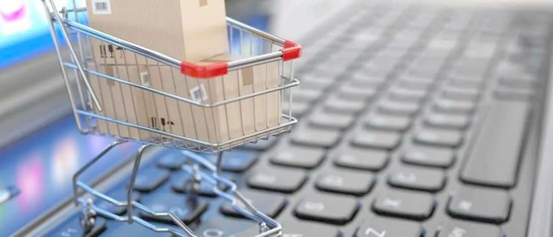 A mini shopping cart on top of a laptop keyboard