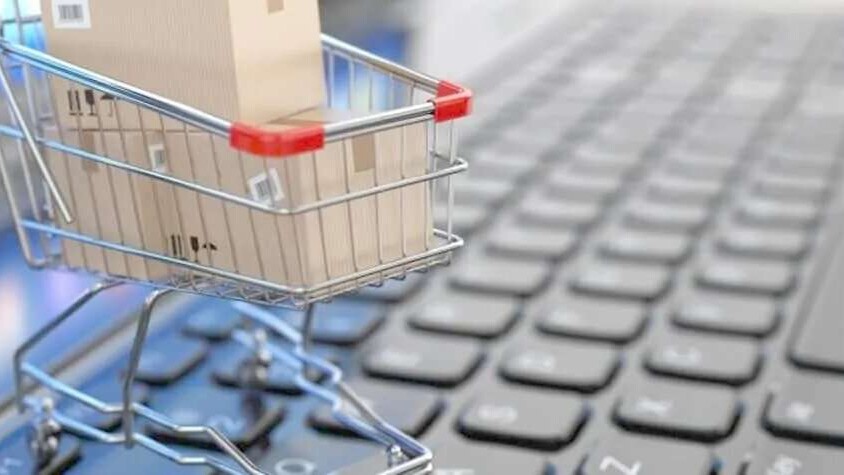 A mini shopping cart on top of a laptop keyboard