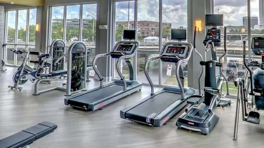 A gym with various cardio and work out equipment