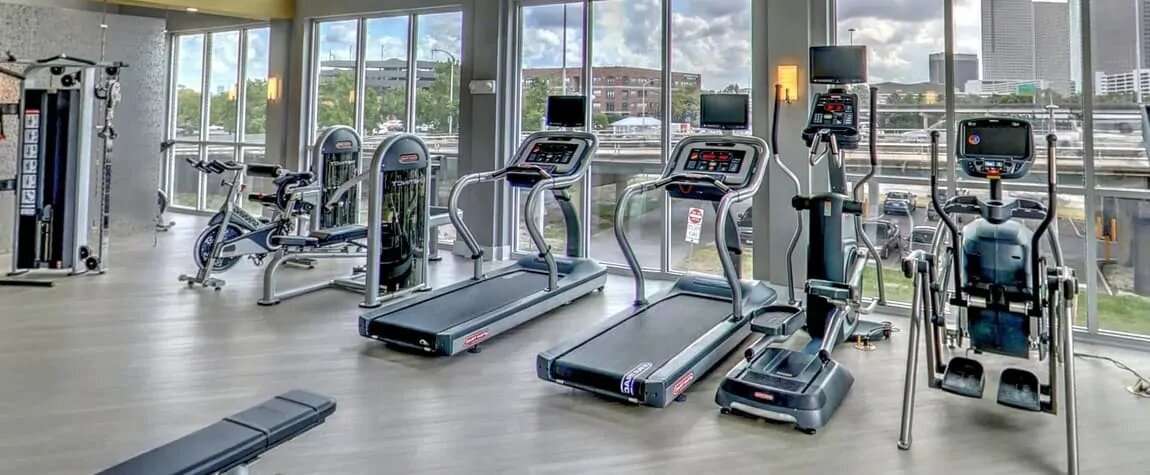 A gym with various cardio and work out equipment