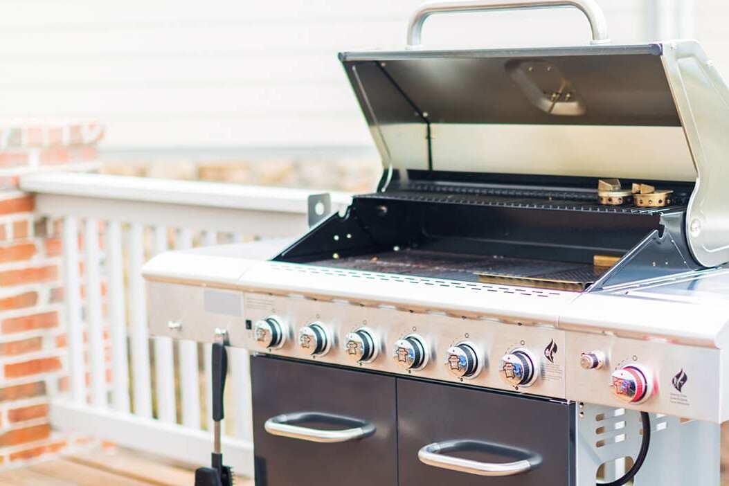 Large grill with the cover open on a home's deck